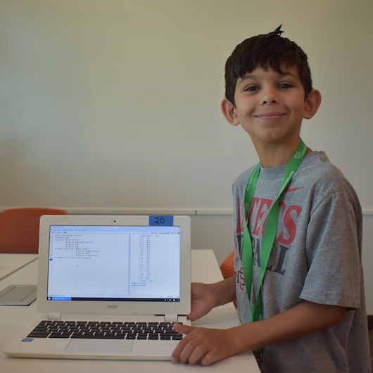 A young student proudly shows off his code.