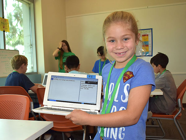 Young girl shows off her code in a computer science camp for elementary school students